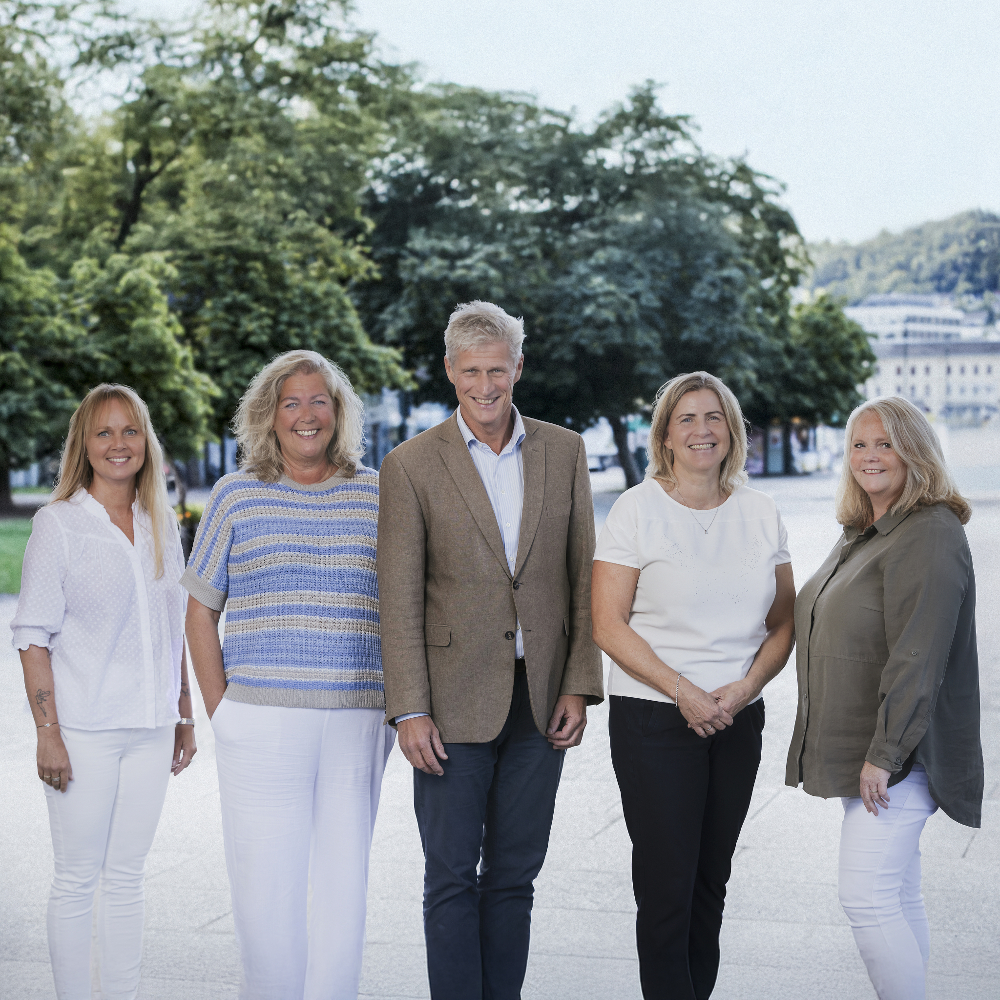 Alle fem ansatte i DKP står oppstilt sammen på en gate i Drammen. Foto.